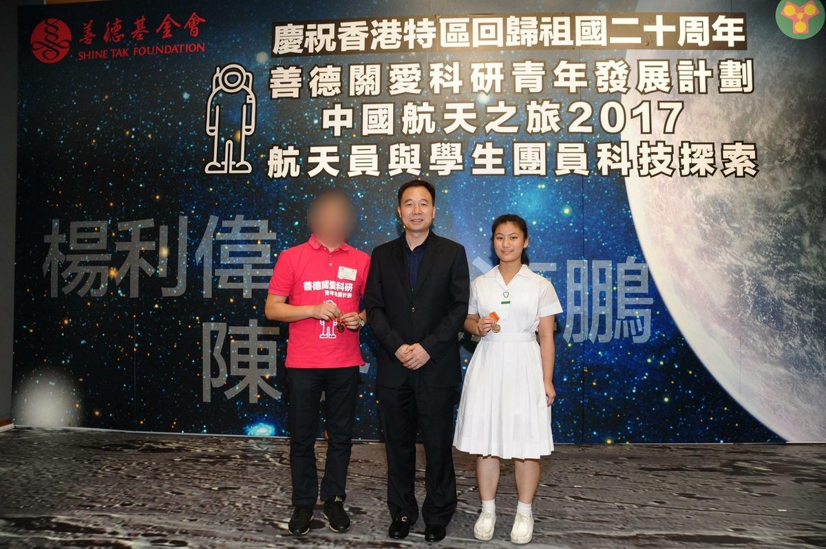 Rhea receiving a medal from astronaut Jing Haipeng at the China Aerospace youth programme, 2017